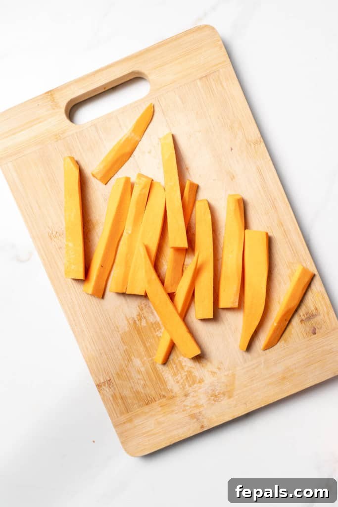 Long sticks of a sweet potato on a cutting board.