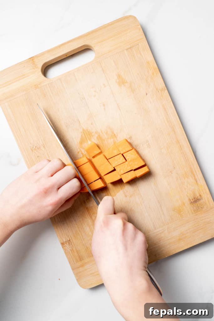 Dicing a sweet potato into cubes.