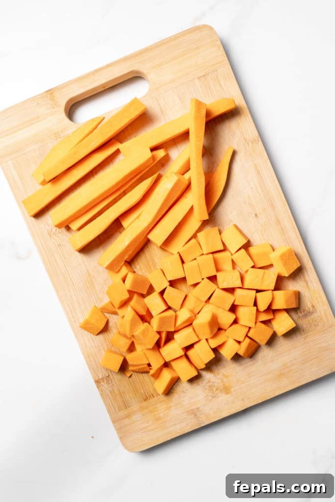 Cubes and sticks of sweet potato on a cutting board.