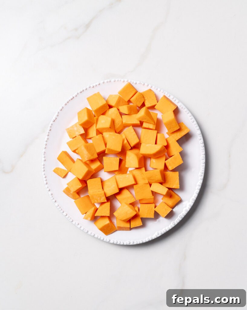 Sweet potatoes cut into cubes on a white plate.