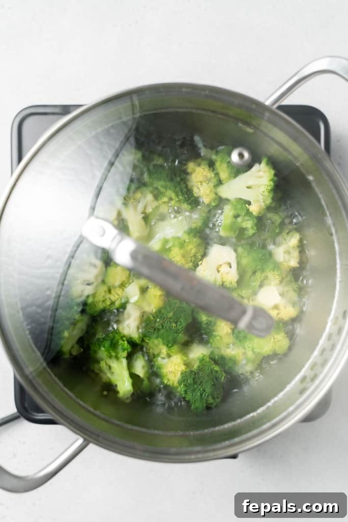 Stovetop Broccoli Perfection 11 Broccoli boiling gently in a covered pot on the stove, steam visible.