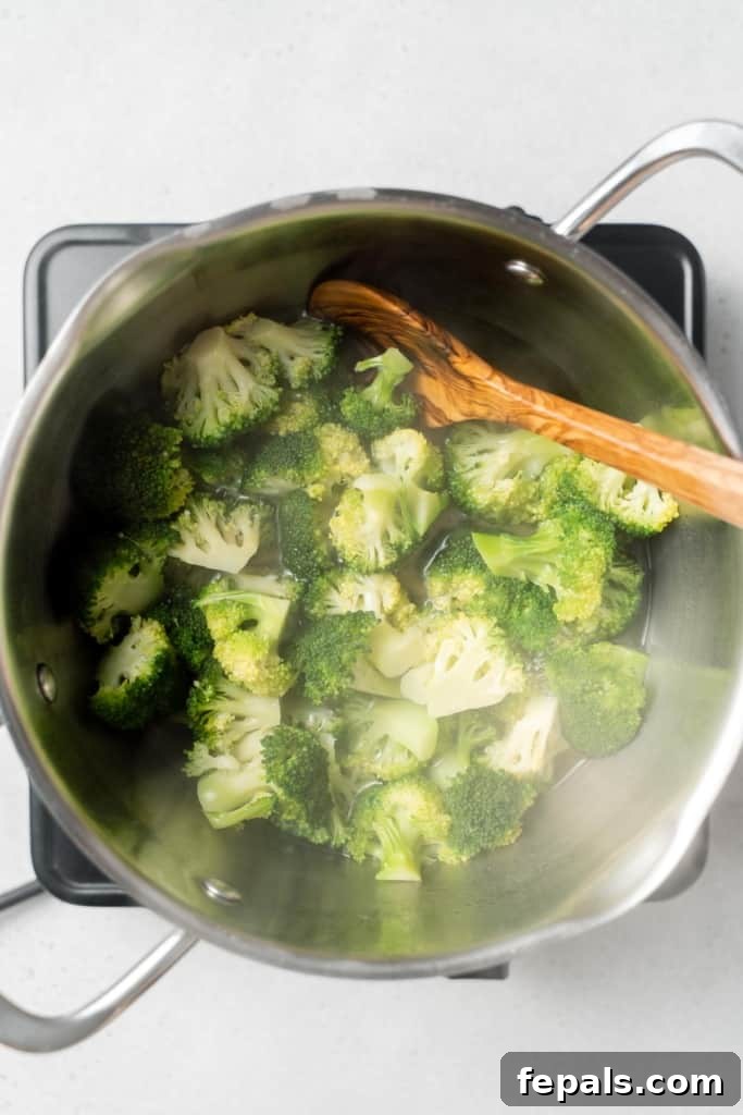 Perfect Stovetop Broccoli 12 Stirring cooked broccoli in a pot.