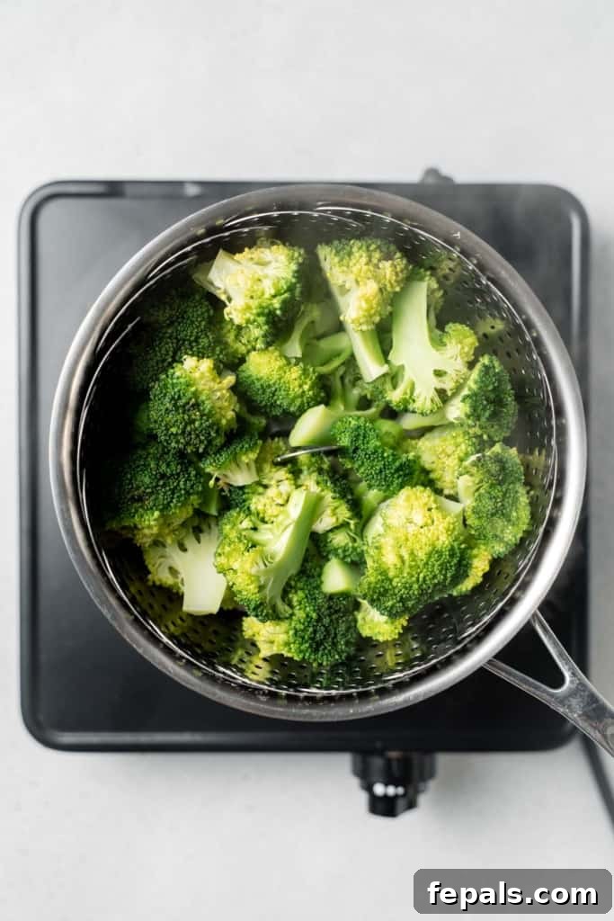 Stovetop Broccoli Perfection 8 Freshly steamed broccoli florets resting in a steamer basket, ready to be removed from the pot.