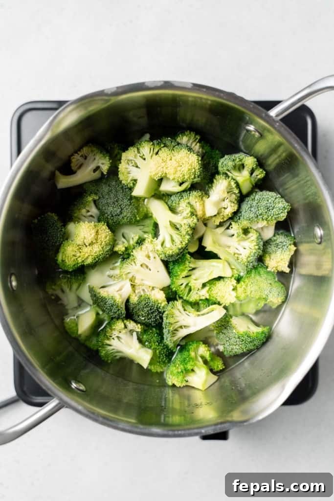 Perfect Stovetop Broccoli 10 Adding broccoli florets to water in a pot.