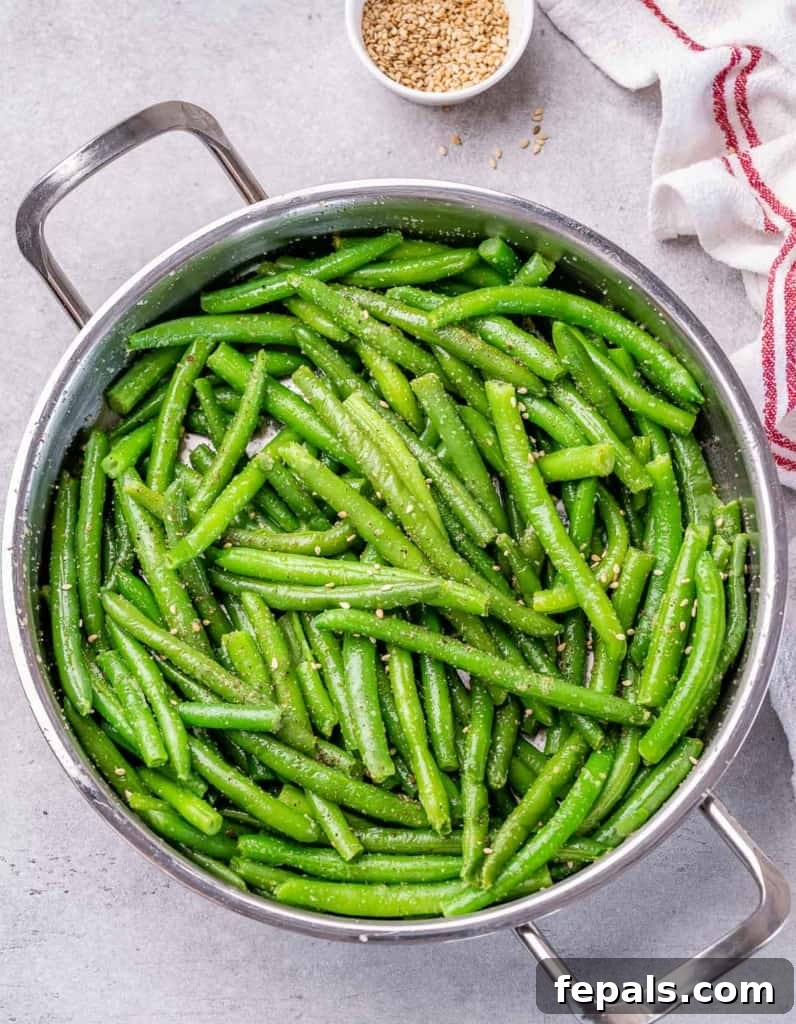 Garlic Sautéed Green Beans 6 Green beans in a pot tossed with sesame seeds.