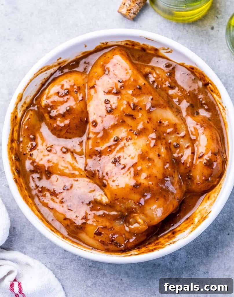 Crispy Honey Chipotle Chicken 6 Marinating chicken breasts in a white bowl.