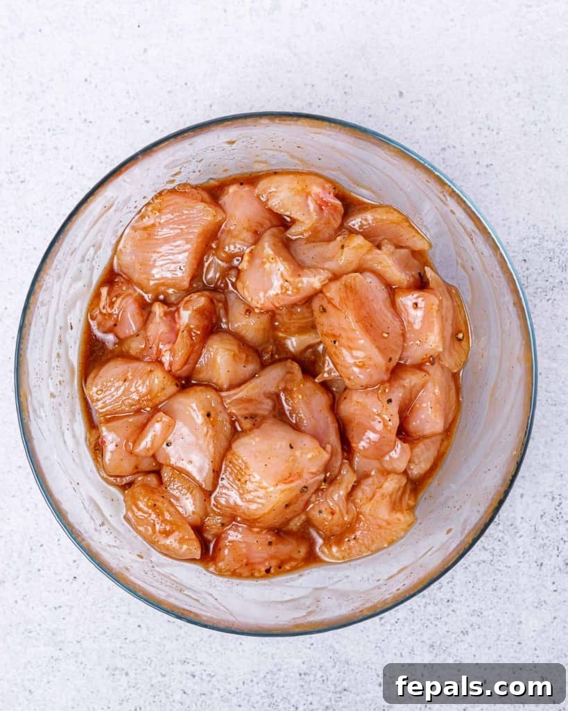 Grilled Umami Chicken Skewers 6 Raw chicken marinating thoroughly in a bowl, absorbing the rich teriyaki sauce.