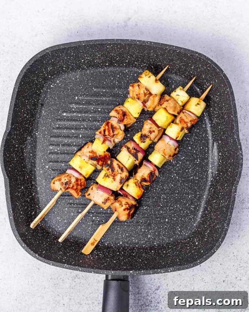 Grilled Umami Chicken Skewers 8 Chicken skewers cooking on a grill pan, showing nice char marks.