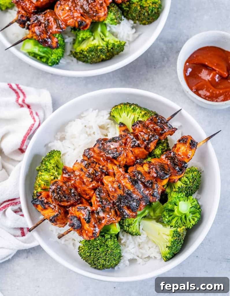 top view of 2 chicken skewers on a round white bowl