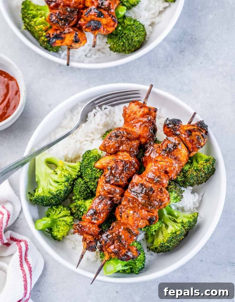 top view of chicken bowl with chicken kabobs over rice and broccoli