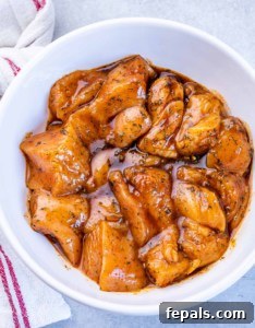 Marinating chicken in a white bowl.