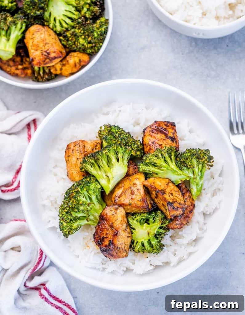 Perfectly cooked broccoli and chicken pieces elegantly served over a bed of fluffy rice, ready for a delicious meal.