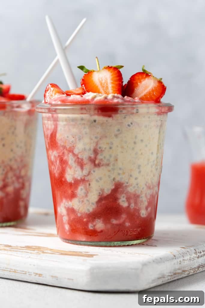 Side shot of a jar with overnight oats and blended fresh strawberries.