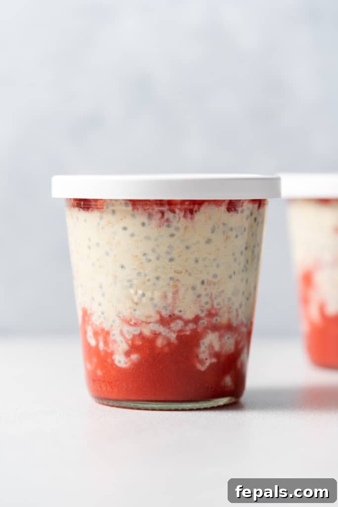 Jar of strawberry overnights oats with a white lid.