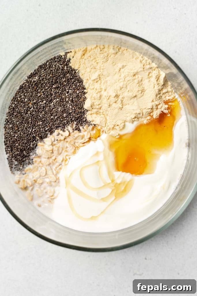 Oats, chia seeds, yogurt and honey added to a bowl.