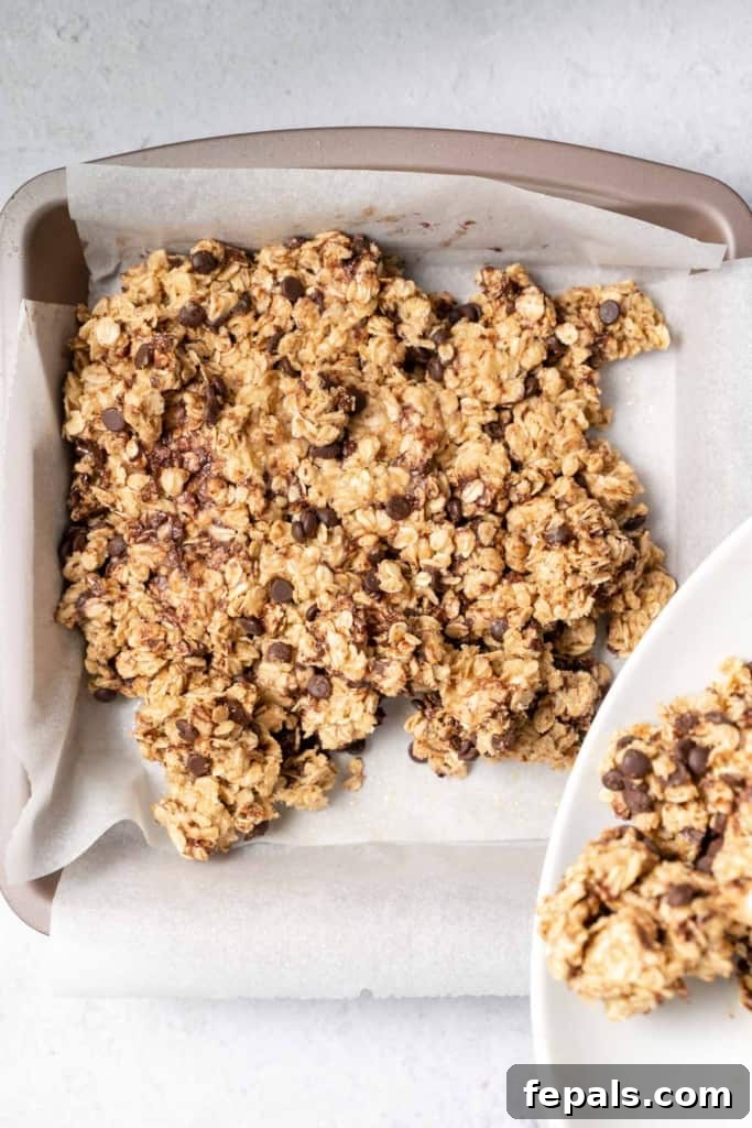 Pouring oat bar mixture into the parchment-lined pan.