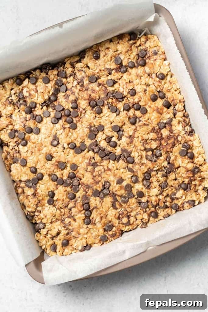 Peanut butter oatmeal bars in a parchment lined pan, chilling to set.
