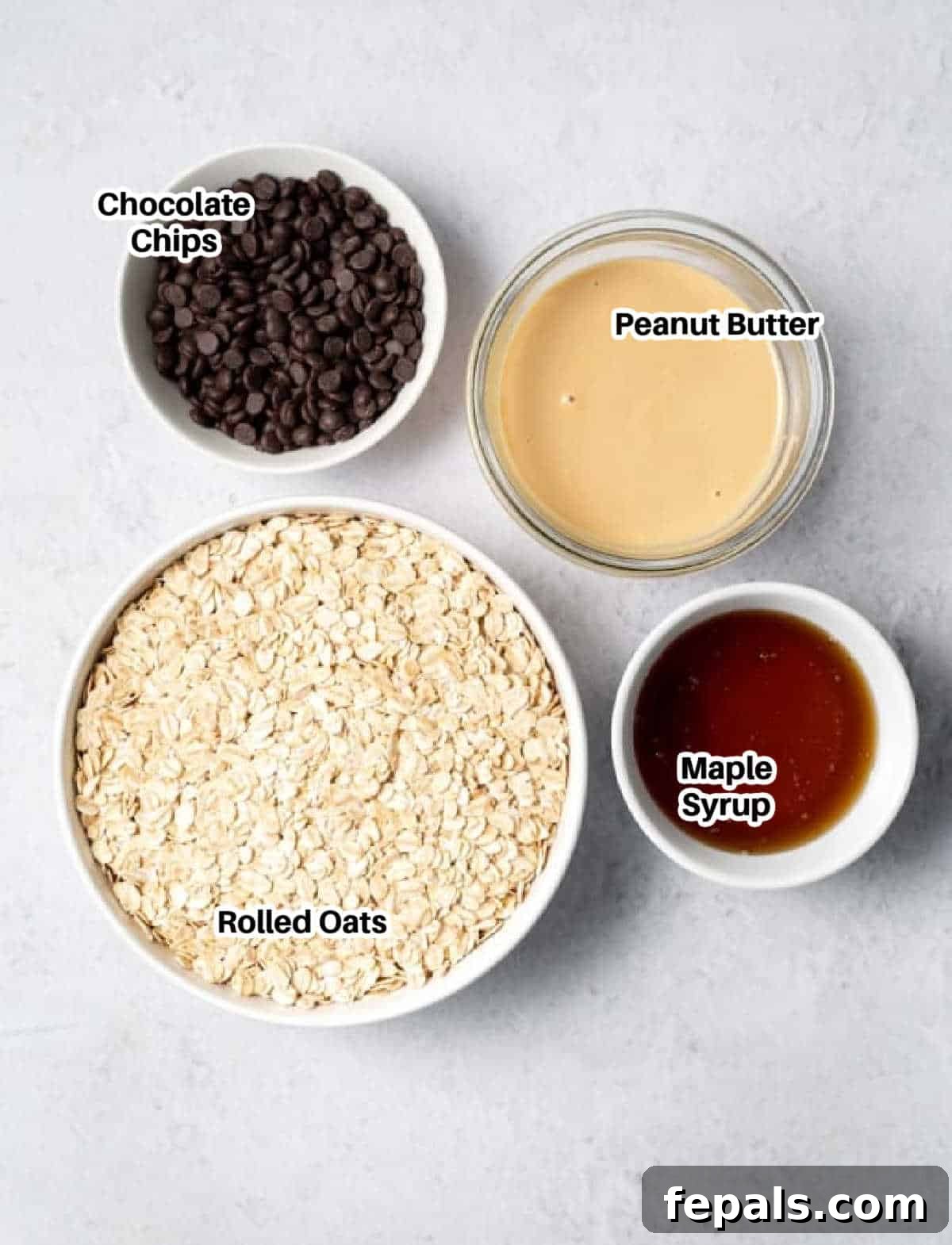 A display of the four simple ingredients needed to make no bake peanut butter bars: peanut butter, honey, rolled oats, and chocolate chips.