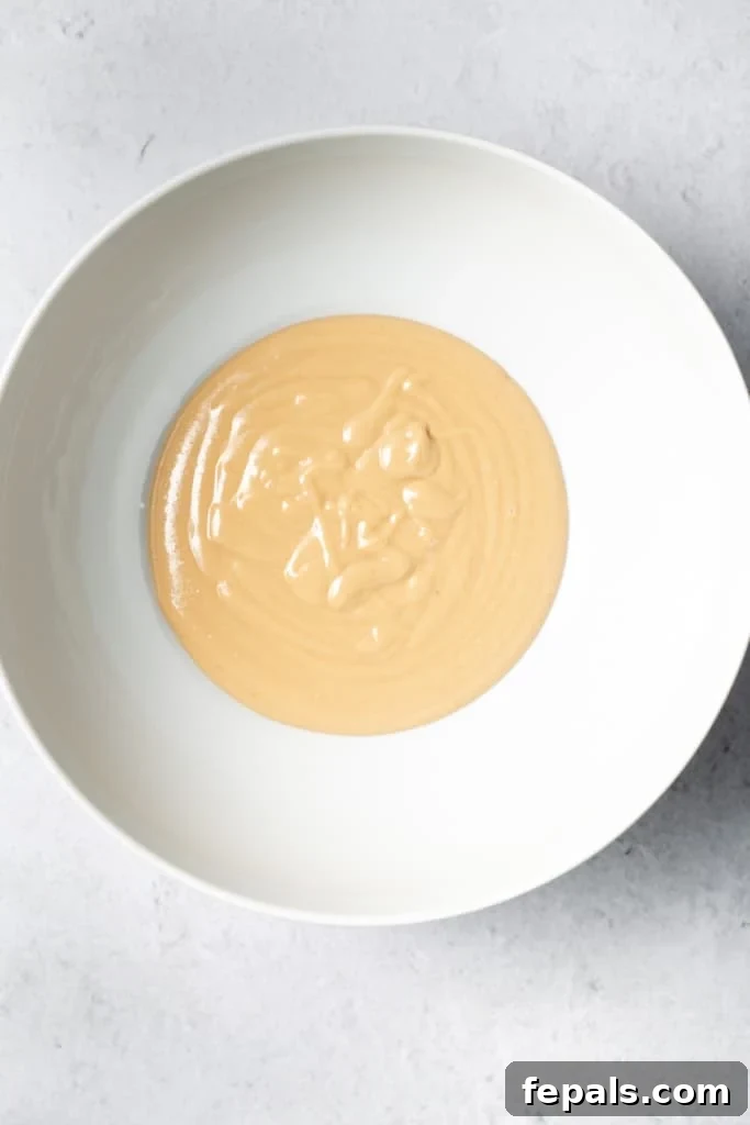 Peanut butter in a white bowl, a primary ingredient for the no-bake bars.