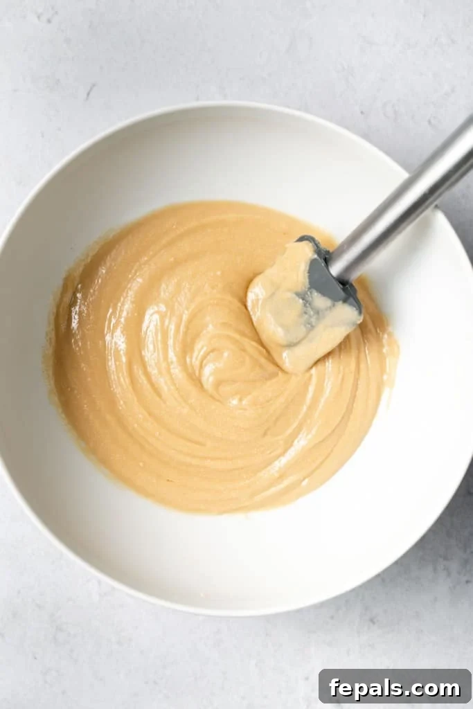 Stirring peanut butter and honey together until smooth and fully combined.