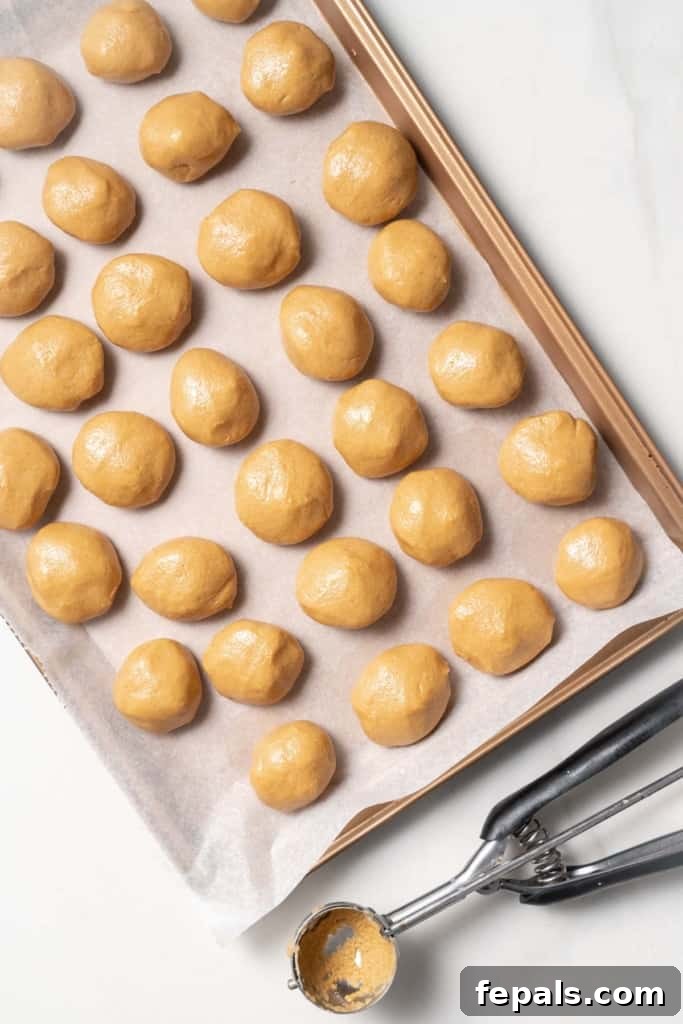 Peanut butter balls on a cookie sheet.