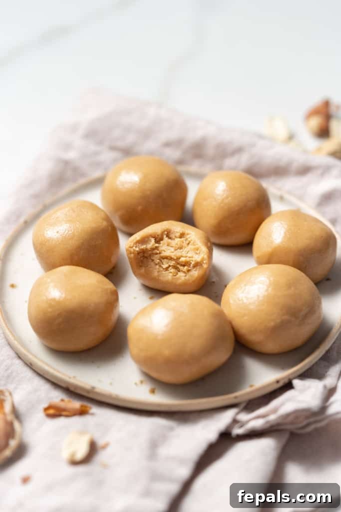 Peanut butter balls on a plate with a bite taken out of one.