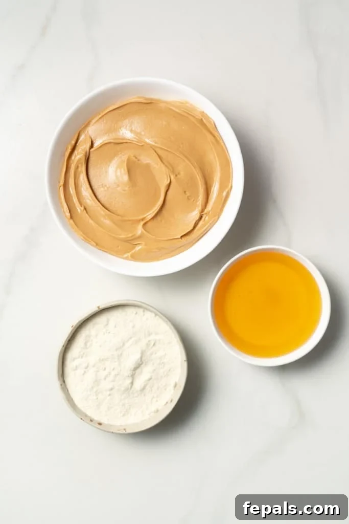 Peanut butter, honey and coconut flour divided into small bowls.