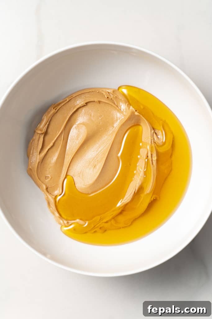 White bowl with peanut butter and honey.