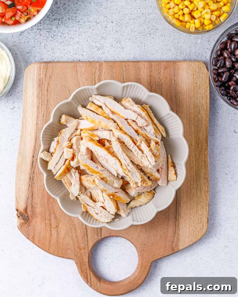 Spicy Southwest Chicken Wrap 5 Perfectly sliced grilled chicken strips arranged on a clean, round white plate.