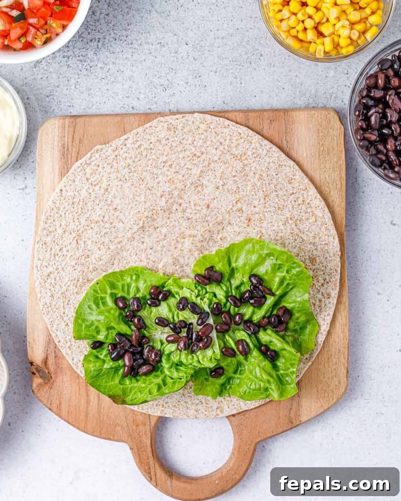 Spicy Southwest Chicken Wrap 7 A generous serving of black beans spread over a bed of crisp lettuce on a warm tortilla wrap.