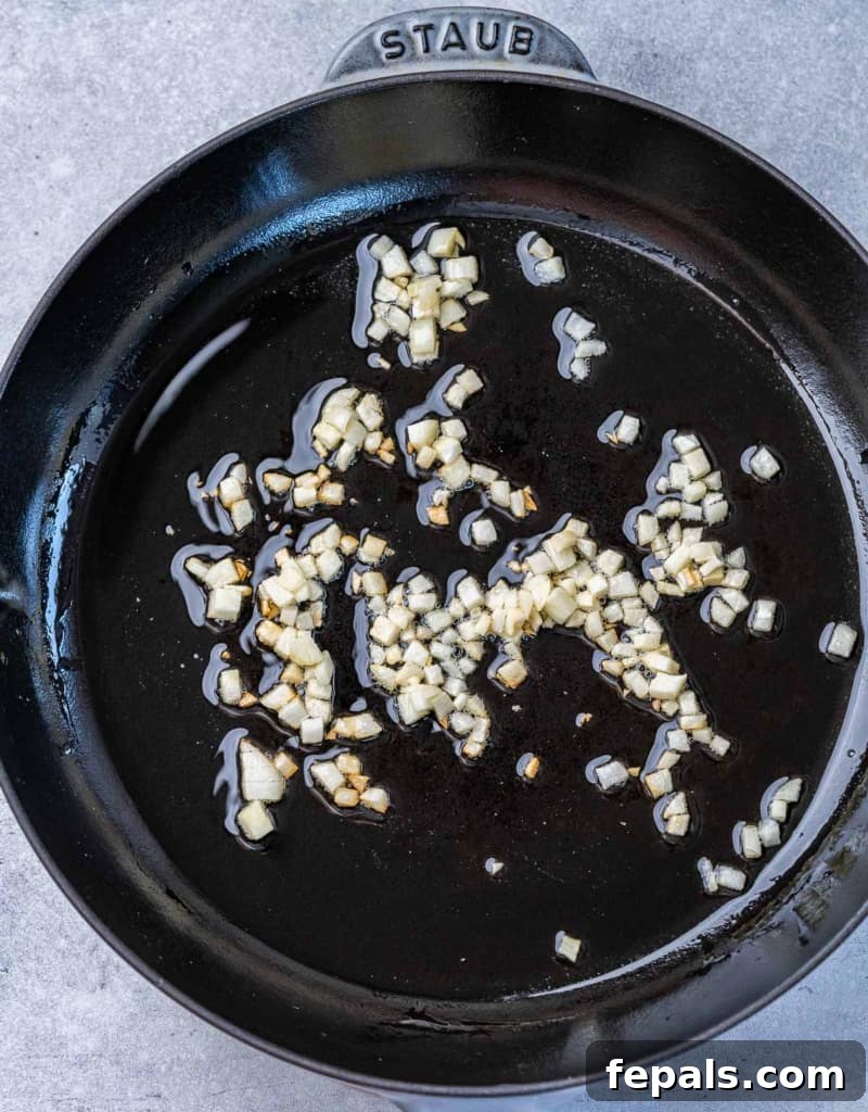 Golden Grits and Gulf Delights 6 Sautéing garlic in a pan.