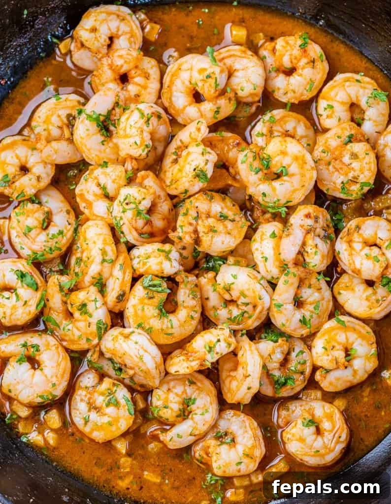 Golden Grits and Gulf Delights 9 Shrimp seasoned and garnished with fresh herbs in a pan.