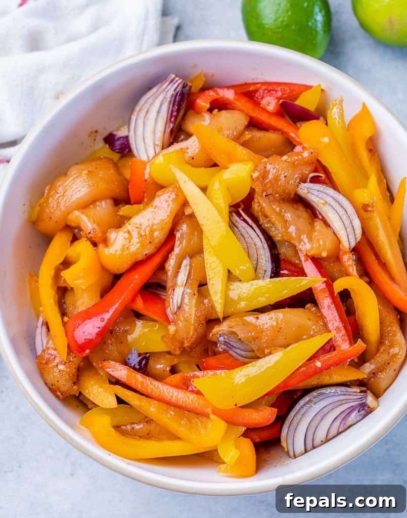 Marinating chicken and veggies in a white bowl.