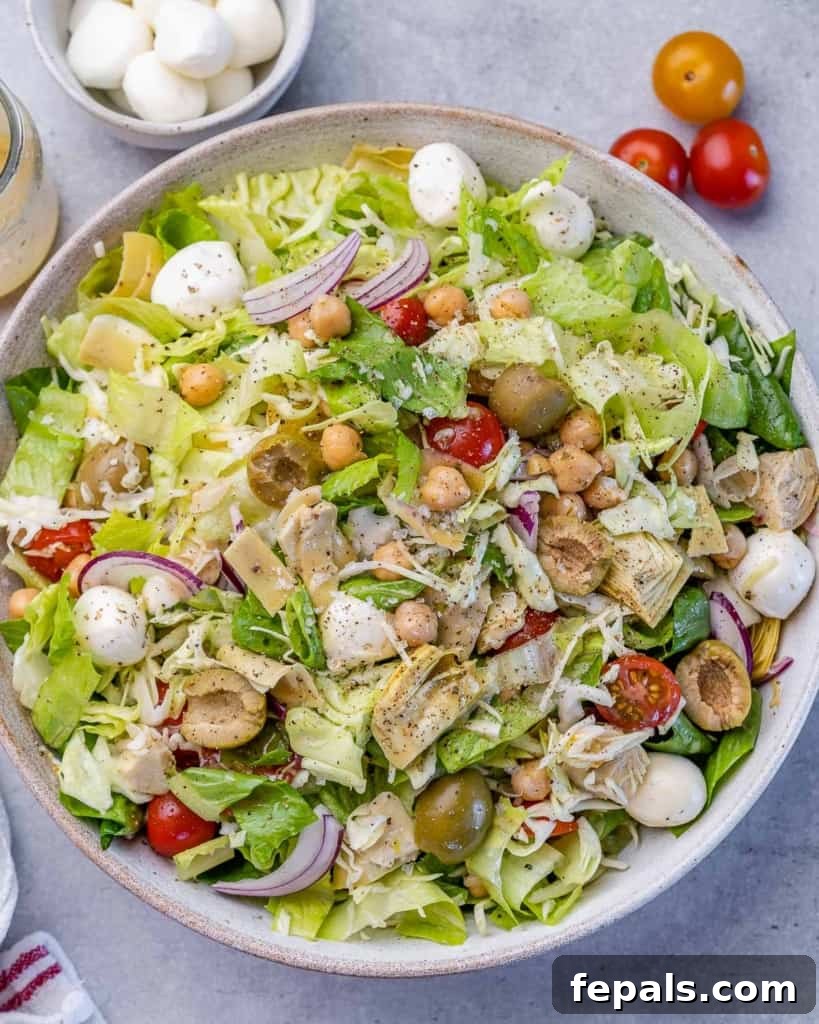 Zesty Italian Chop 2 top view chopped salad in a round white bowl, brimming with fresh ingredients