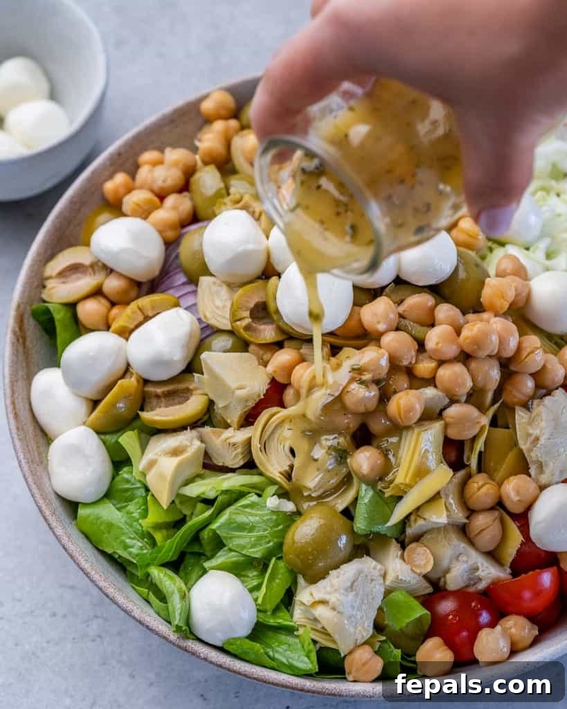 Zesty Italian Chop 7 dressing being added over chopped salad, bringing all the flavors together