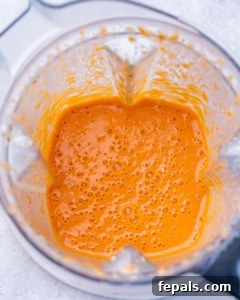 Blended roasted red pepper sauce in a blender, smooth and creamy in texture.