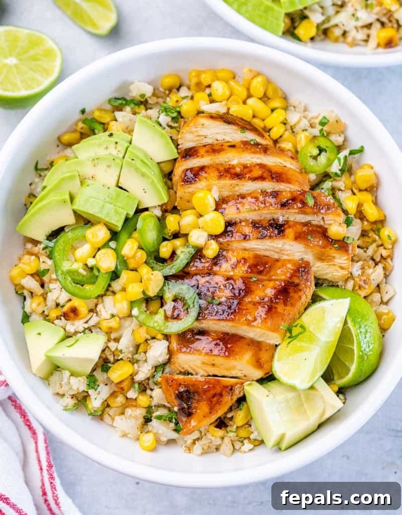Smoky Chipotle Chicken Rice Bowl 9 top view of a white bowl with cauliflower rice, corn, and sliced cooked chicken breast