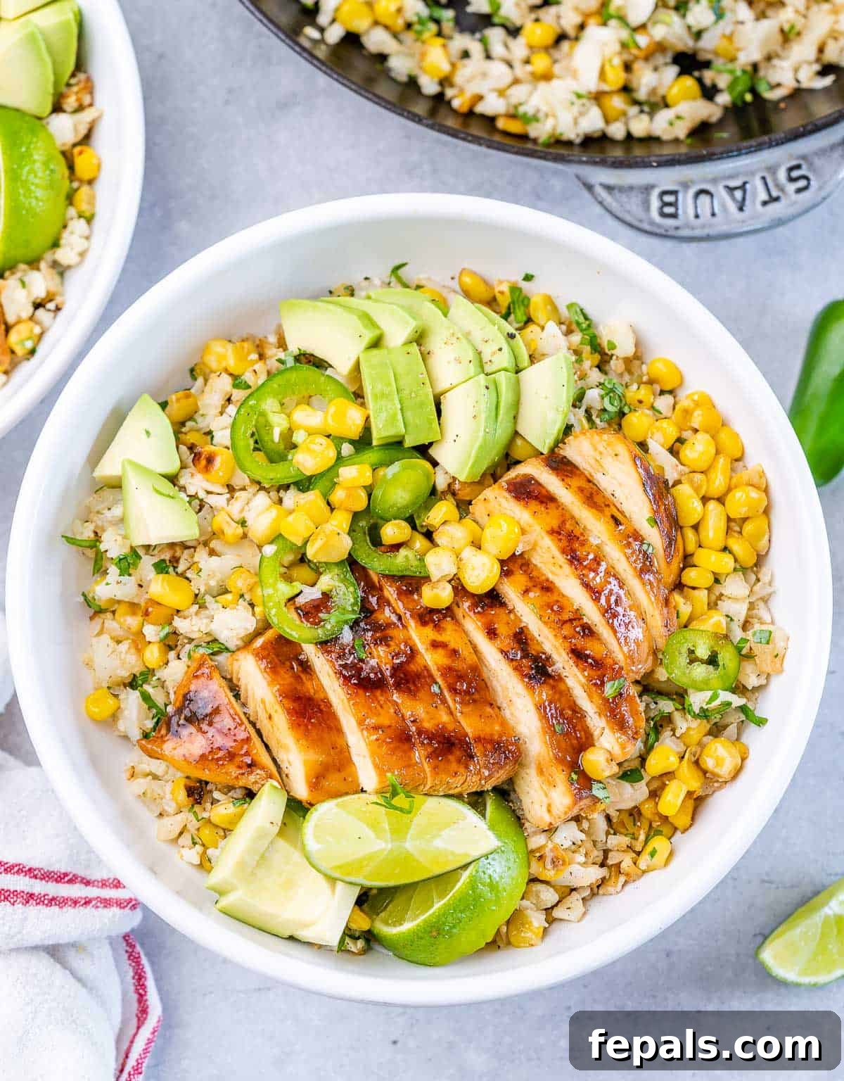 Smoky Chipotle Chicken Rice Bowl 10 Chipotle chicken rice bowl served with sliced avocado and lime wedges.