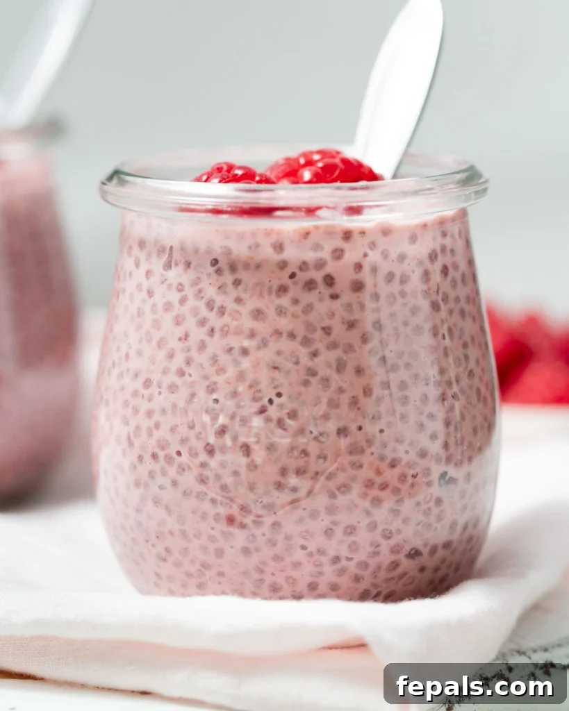side shot of raspberry chia pudding in a jar, showcasing its beautiful pink hue and creamy texture