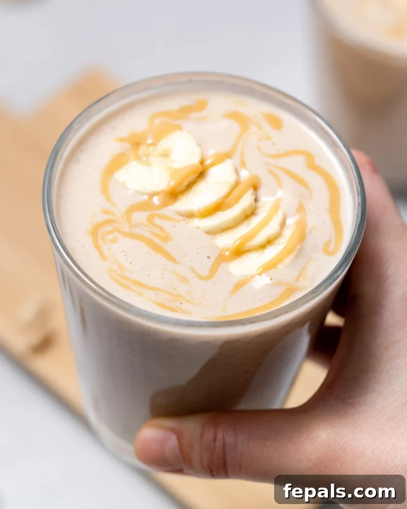 Nutty Banana Bliss Smoothie 3 Woman holding a peanut butter banana smoothie.