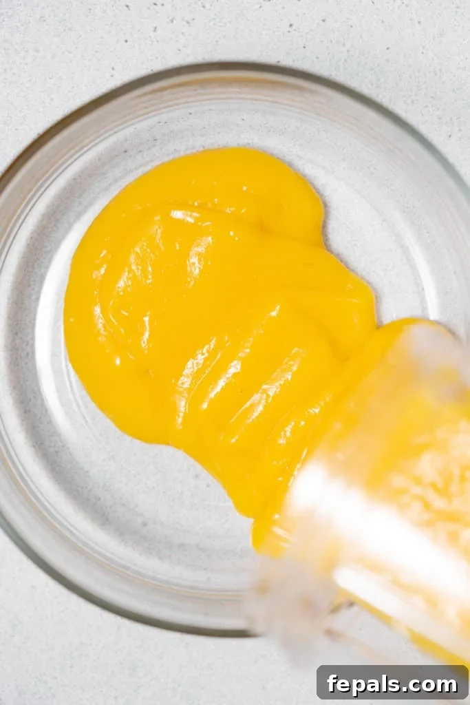 Tropical Mango Chia Bliss 7 pureed mango being poured over a bowl