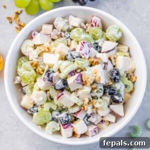 Top view salad with fruits and nuts in a round bowl.