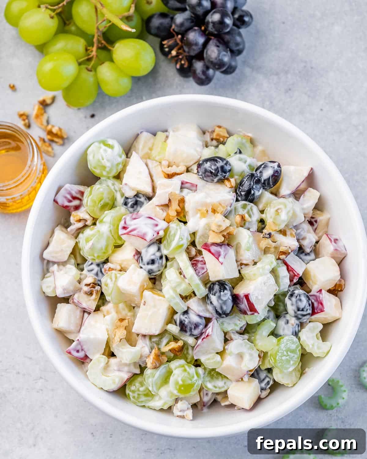 Waldorf Salad fully mixed with creamy dressing in a white bowl.