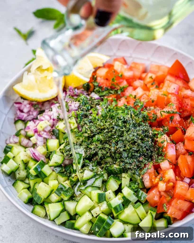 Refreshing Persian Shirazi Salad 7 Extra virgin olive oil being drizzled over the bowl of chopped vegetables and herbs for the Shirazi Salad.