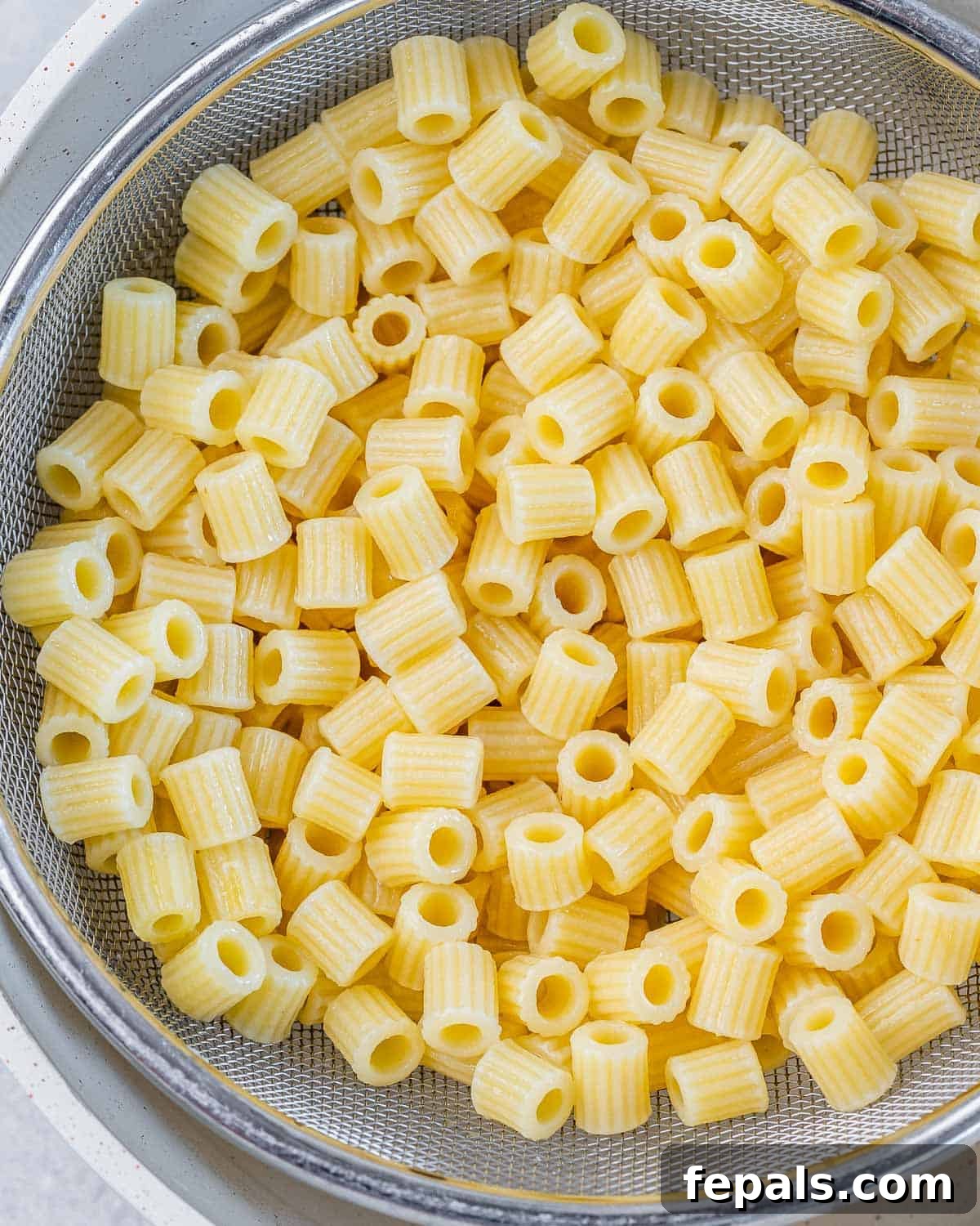 Boiled pasta in a colander.