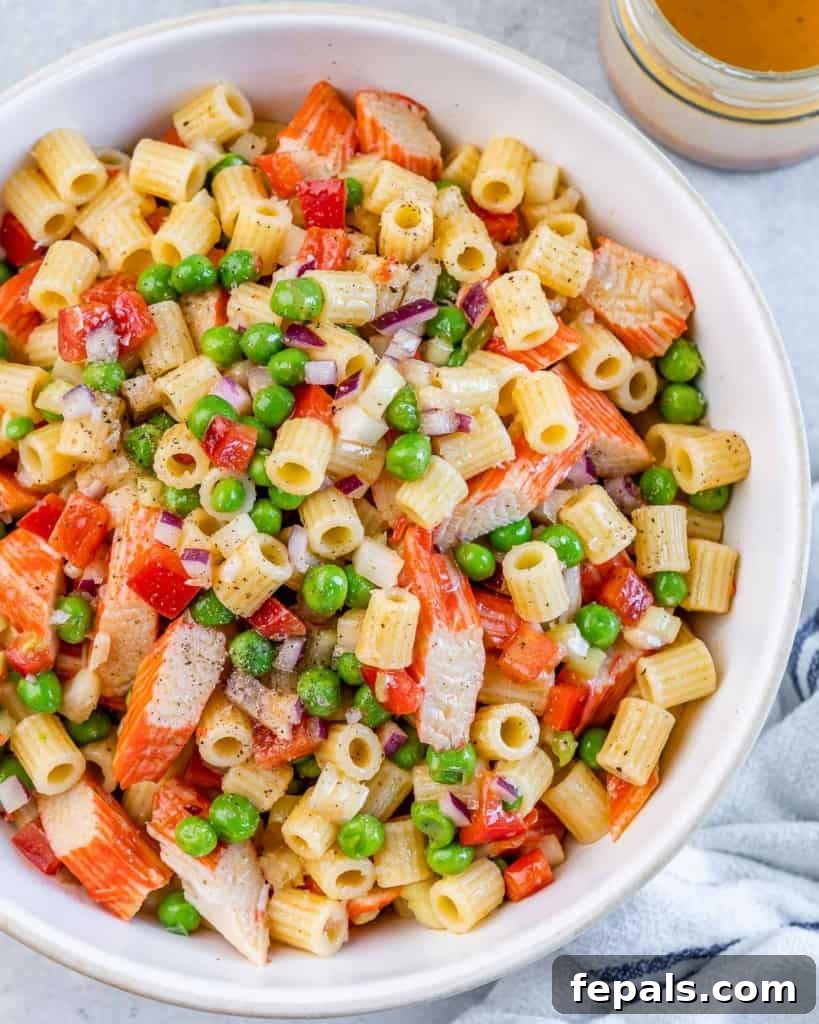 Pasta salad tossed with crab, peas and red onion.
