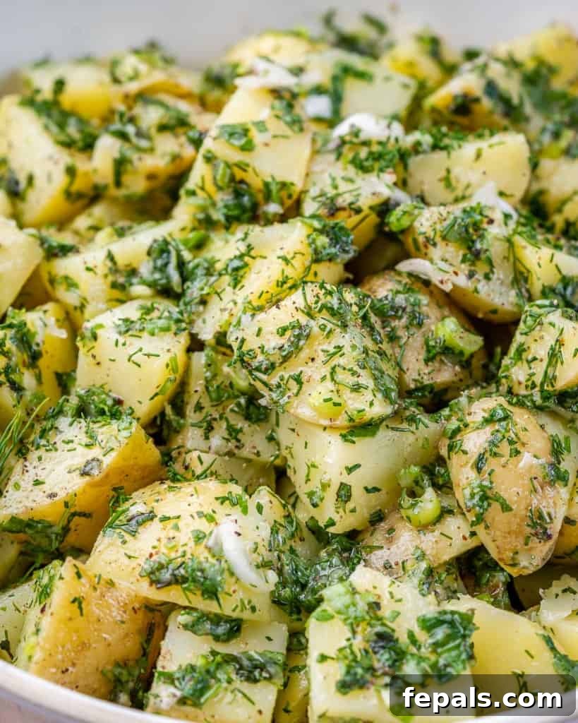 A striking close-up image of a vibrant green herbed potato salad, highlighting its fresh texture and appealing color.