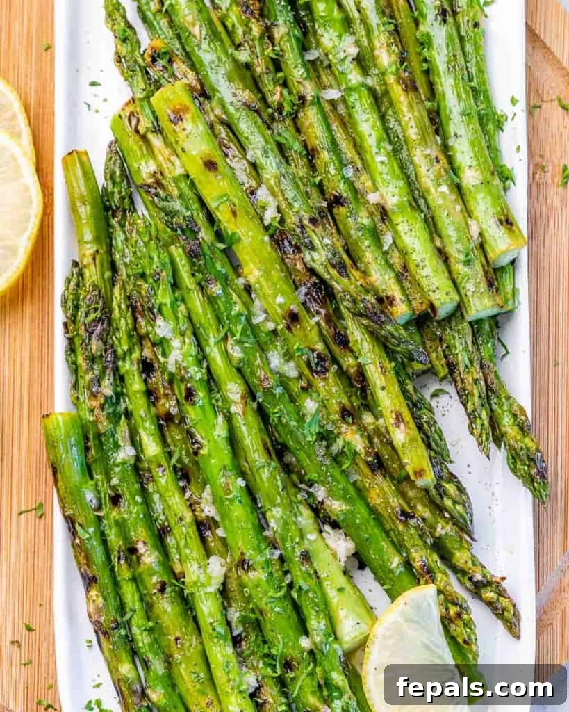 Charred Asparagus with Zesty Lemon-Garlic 3 Grilled asparagus served on a white plate.