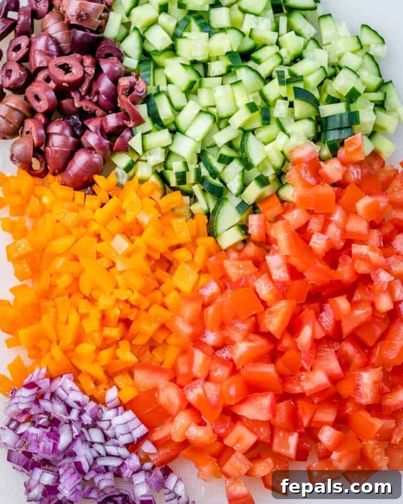 Savory Vegetable Spirals 5 Finely chopped cucumbers, tomatoes, peppers, and onions arranged on a cutting board, ready for assembling the pinwheels.