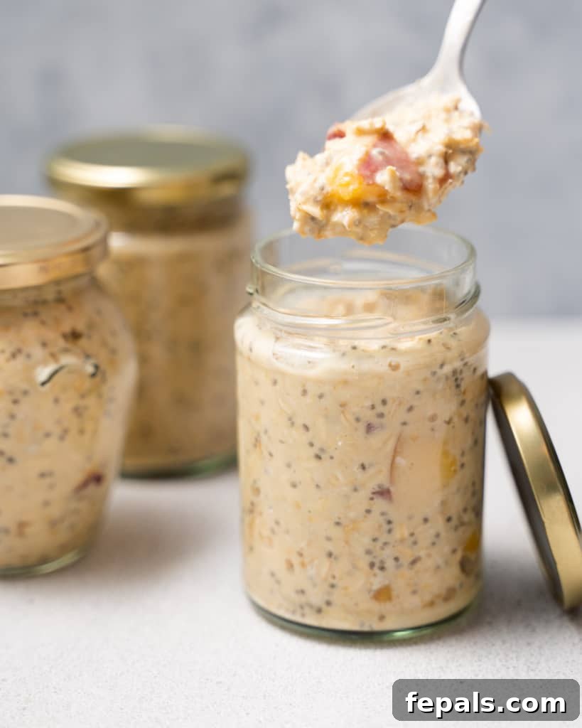 Velvet Peach Dream Oats 17 Spooning out peach overnight oats from a jar.